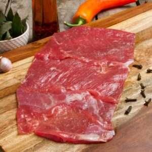 bistec de cecina de res sobre tabla de madera lista para cocinar