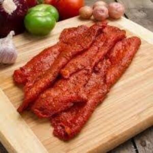bistec de carne de cerdo crudos, cubiertos de adobo rojo y espeso