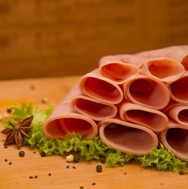 Rebanadas de jamon virginia de pavo sobre especias y tabla de madera