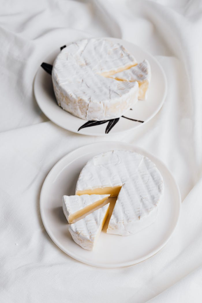 Creamy camembert cheese with slices on elegant ceramic plates, perfect for gourmet presentations.
