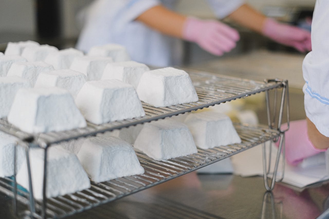 Close-up of artisanal cheese wheels on racks in a modern dairy factory.