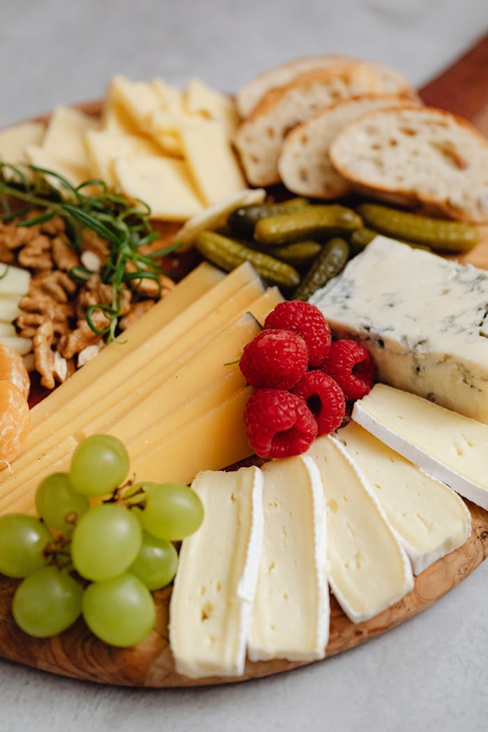 creative Close-up of a gourmet cheese board featuring various cheeses, fruits, and nuts.