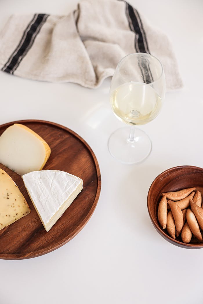 Services-01 A cheese platter paired with white wine, perfect for a sophisticated gathering.