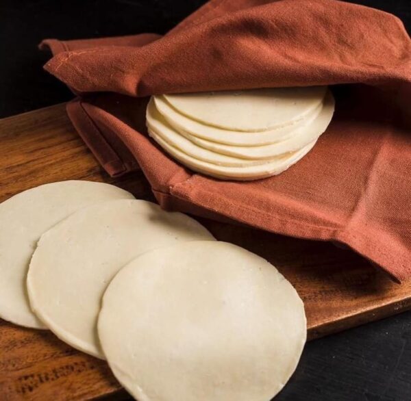 Rebanadas de Queso Asadero apiladas, mostrando su textura suave y color crema
