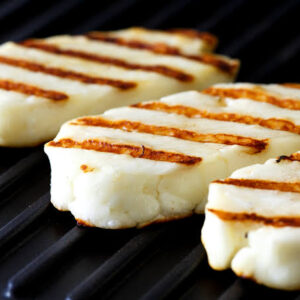 Rebanadas de Queso Asadero apiladas, mostrando su textura suave y color crema